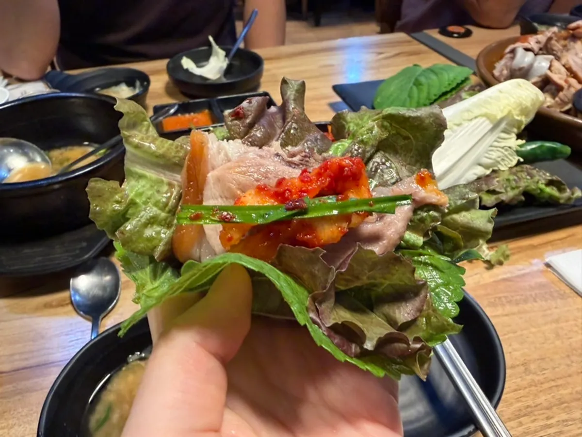 A piece of regular jokbal topped with dried radish strips and chive salad