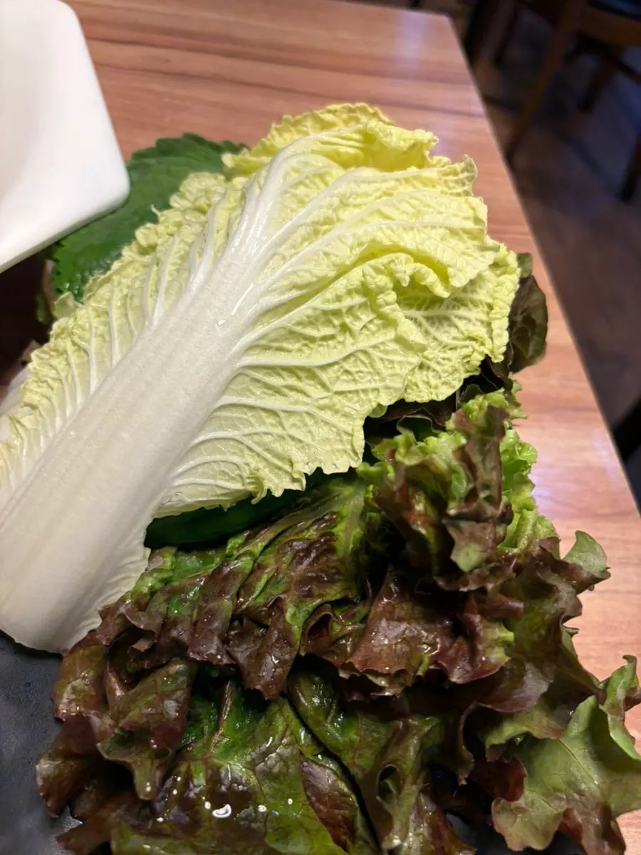 Plate of lettuce, perilla leaves, and cabbage for wraps