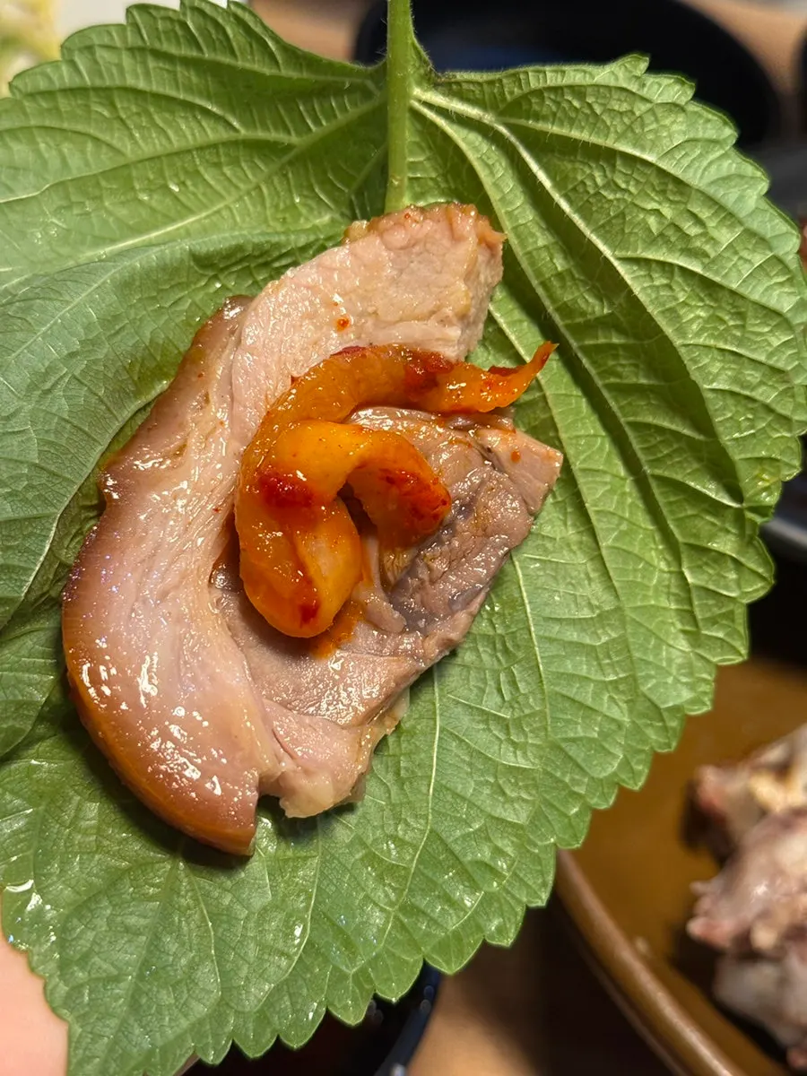A piece of front leg jokbal dipped in salted shrimp sauce
