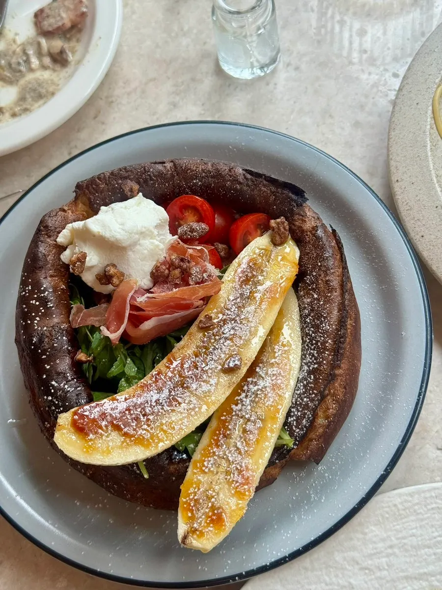 Popover pancakes topped with grilled banana and bacon