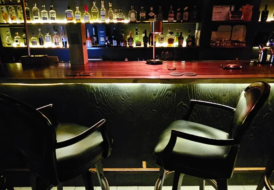 A wall filled with whiskey and cocktail spirit bottles
