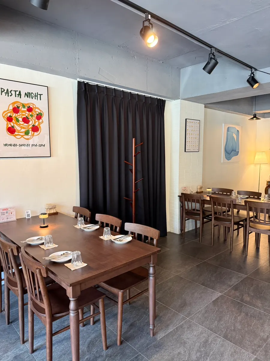 THE MUA interior with wood-toned tables and soft lighting