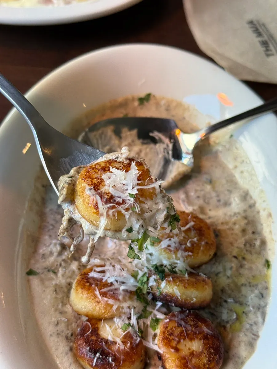 Mushroom gnocchi topped with brown enoki mushrooms