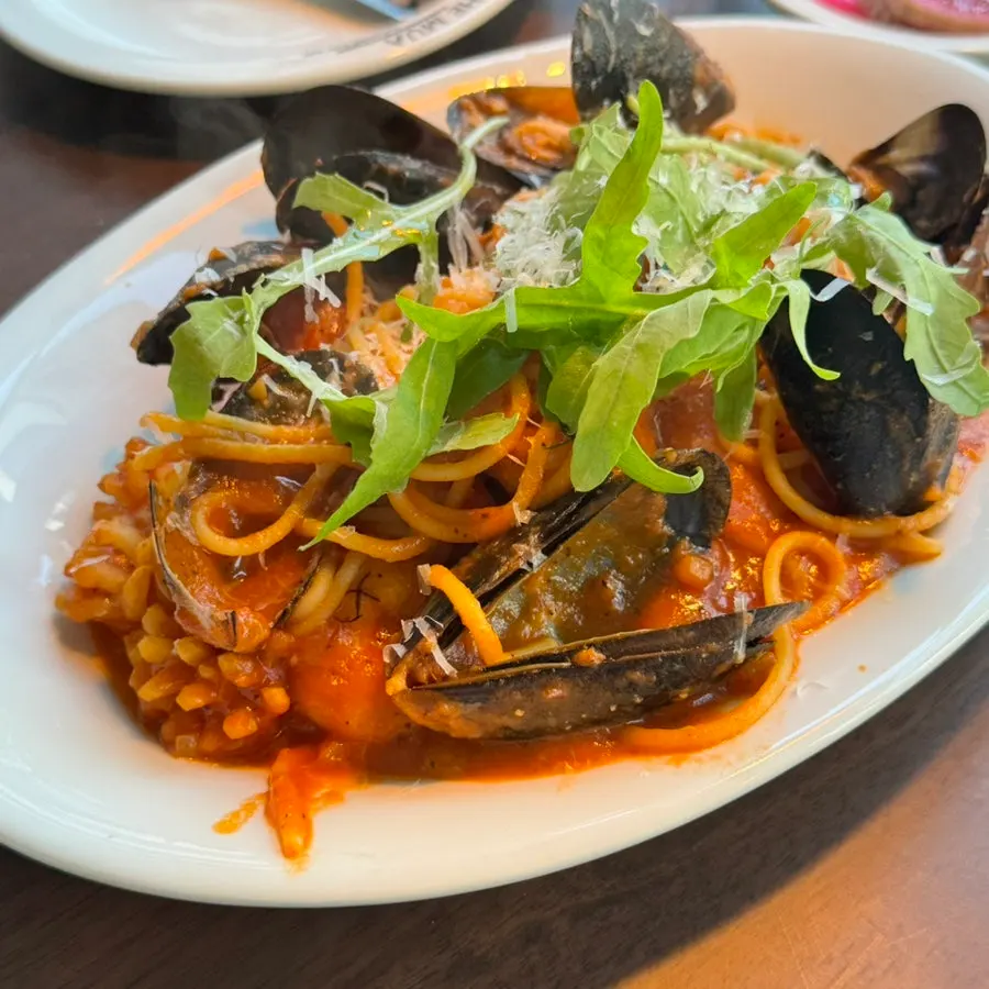 Smoky mare pasta topped with mussels and arugula