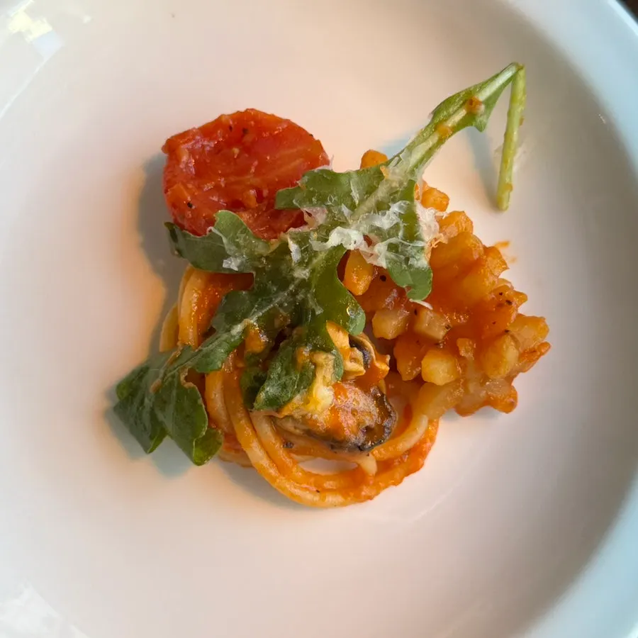 A bite of seafood pasta coated in tomato sauce