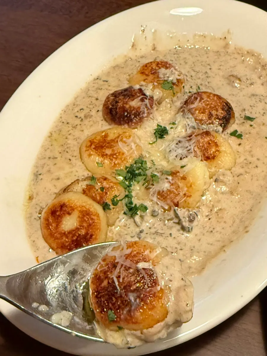 A spoonful of ricotta gnocchi with mushroom sauce