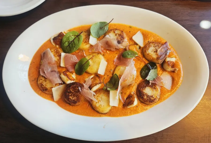 Rosé gnocchi topped with halloumi cheese and prosciutto
