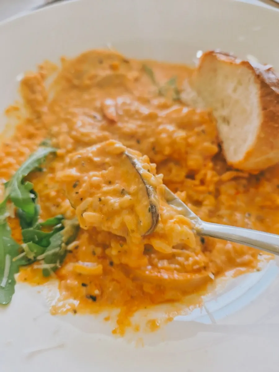 Close-up of rosé risotto topped with shrimp