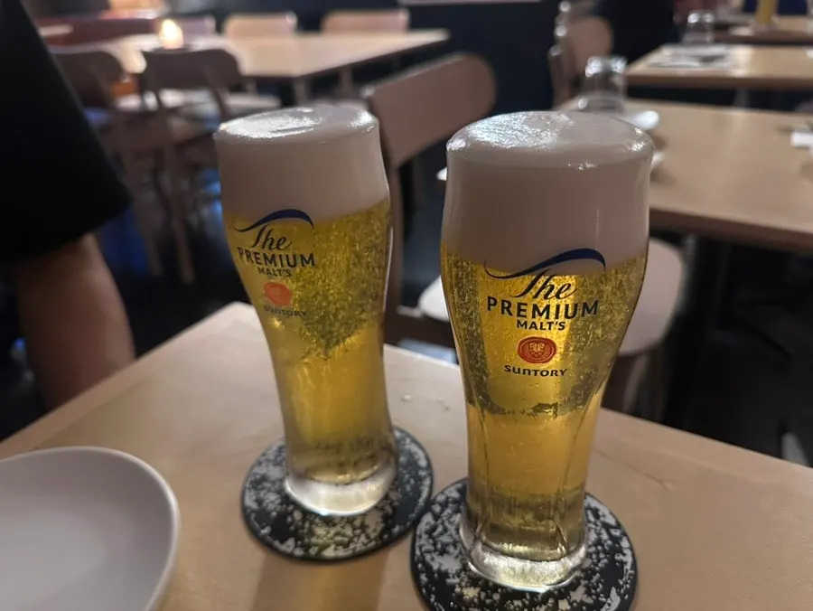 Two glasses of draft beer with foam on top