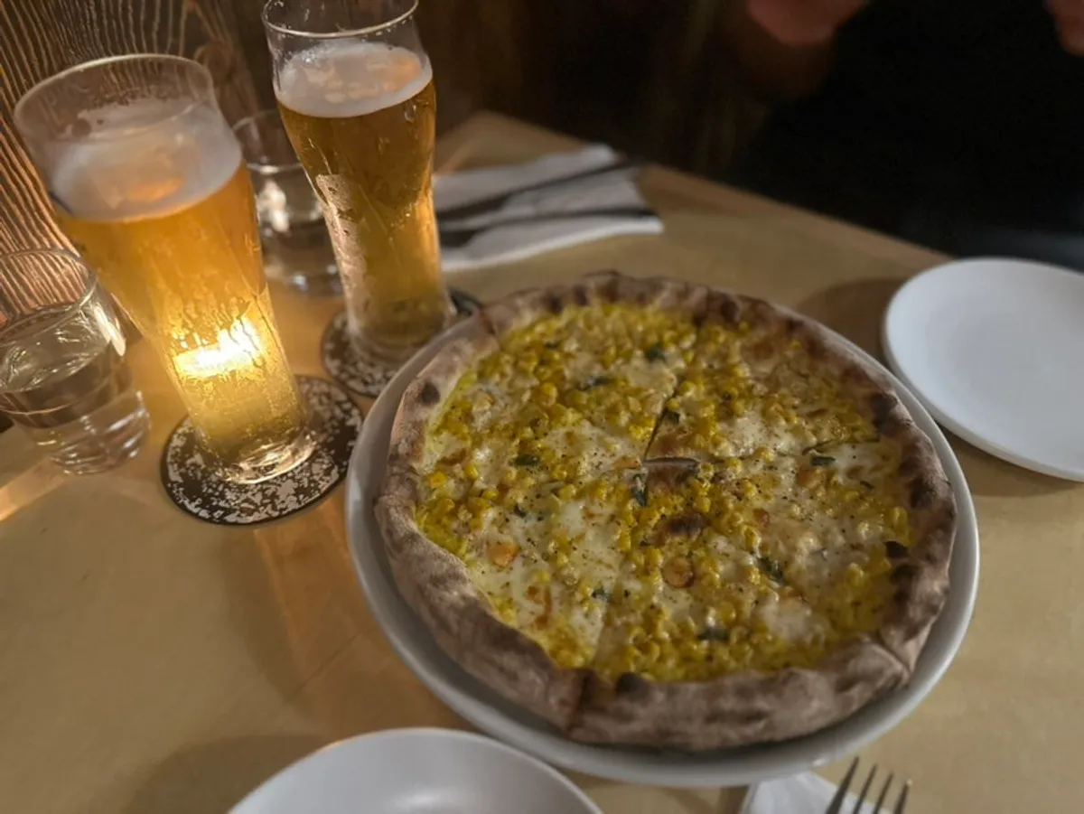 Taleggio pizza topped generously with sweet corn