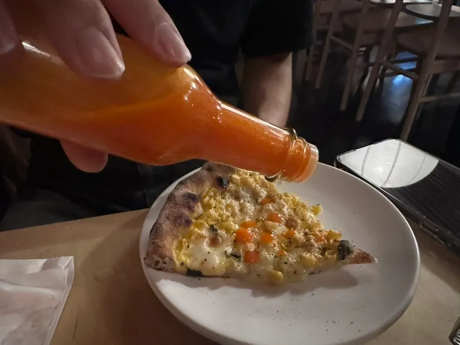 A plate set beside the pizza