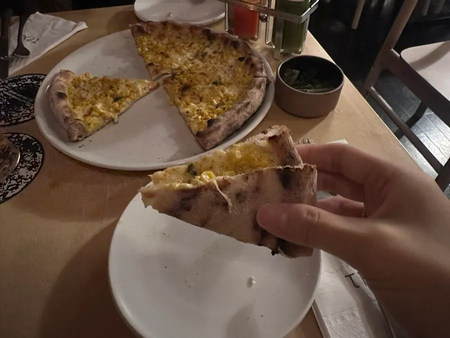Sweet corn pizza topped with hot sauce
