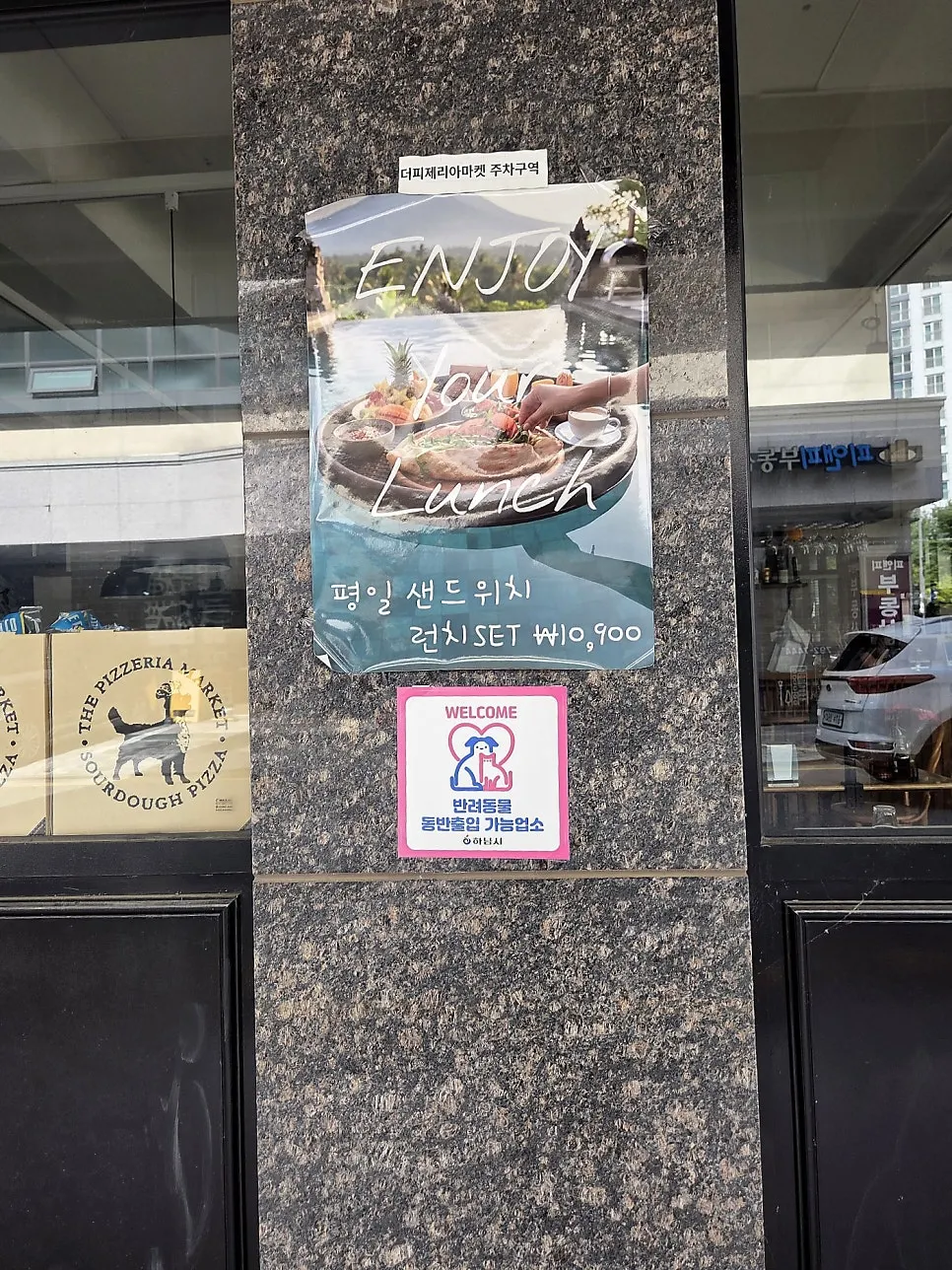 Sign indicating The Pizzeria Market is an approved dog-friendly restaurant