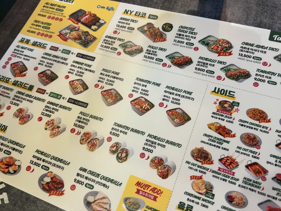 Menu board listing tacos, poke, and burritos at The Taco Booth