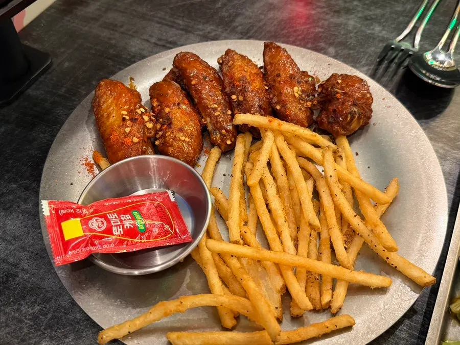 A plate of buffalo wings and fries