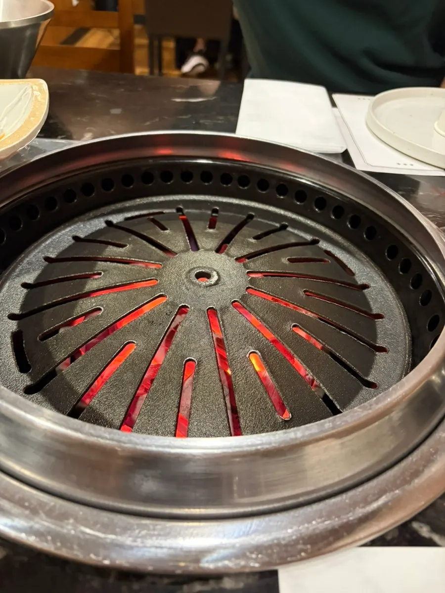 Thick black pork belly with score marks being grilled