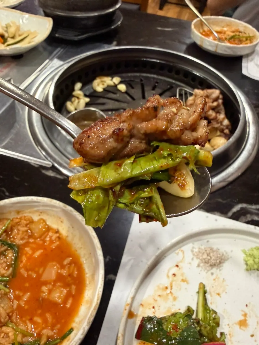 A wrap of black pork with side dishes on top