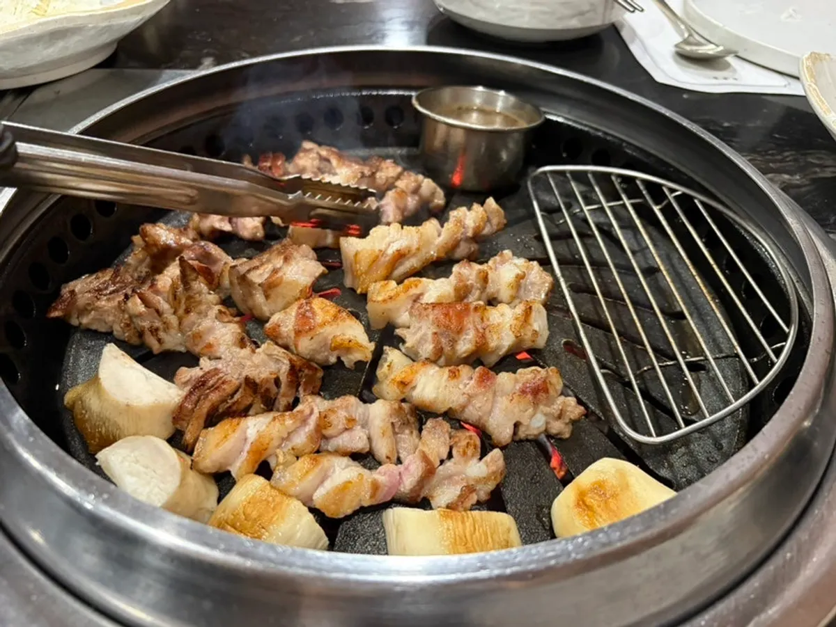 A table spread enjoying black pork neck as a samhap wrap
