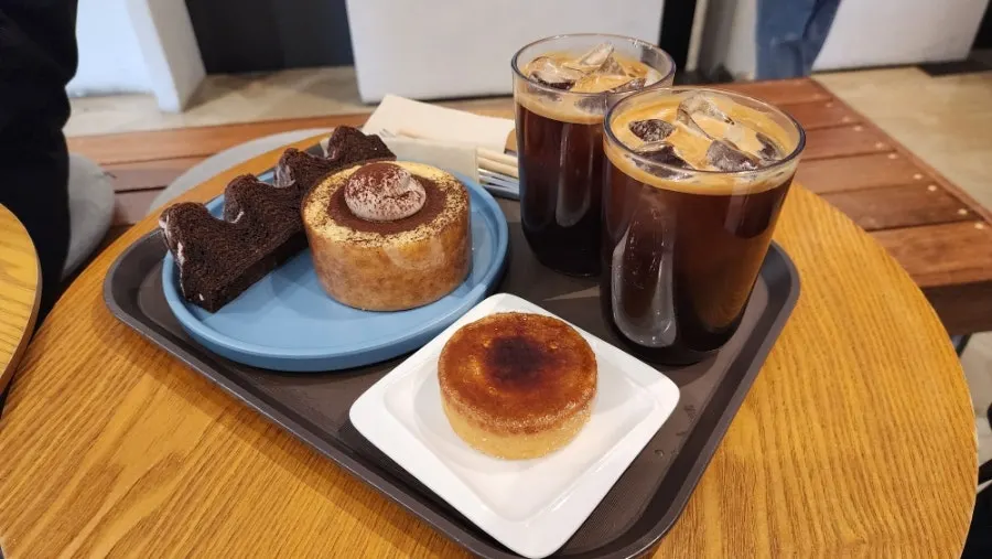 테이블에 놓인 바움쿠헨 세 종류와 아메리카노
