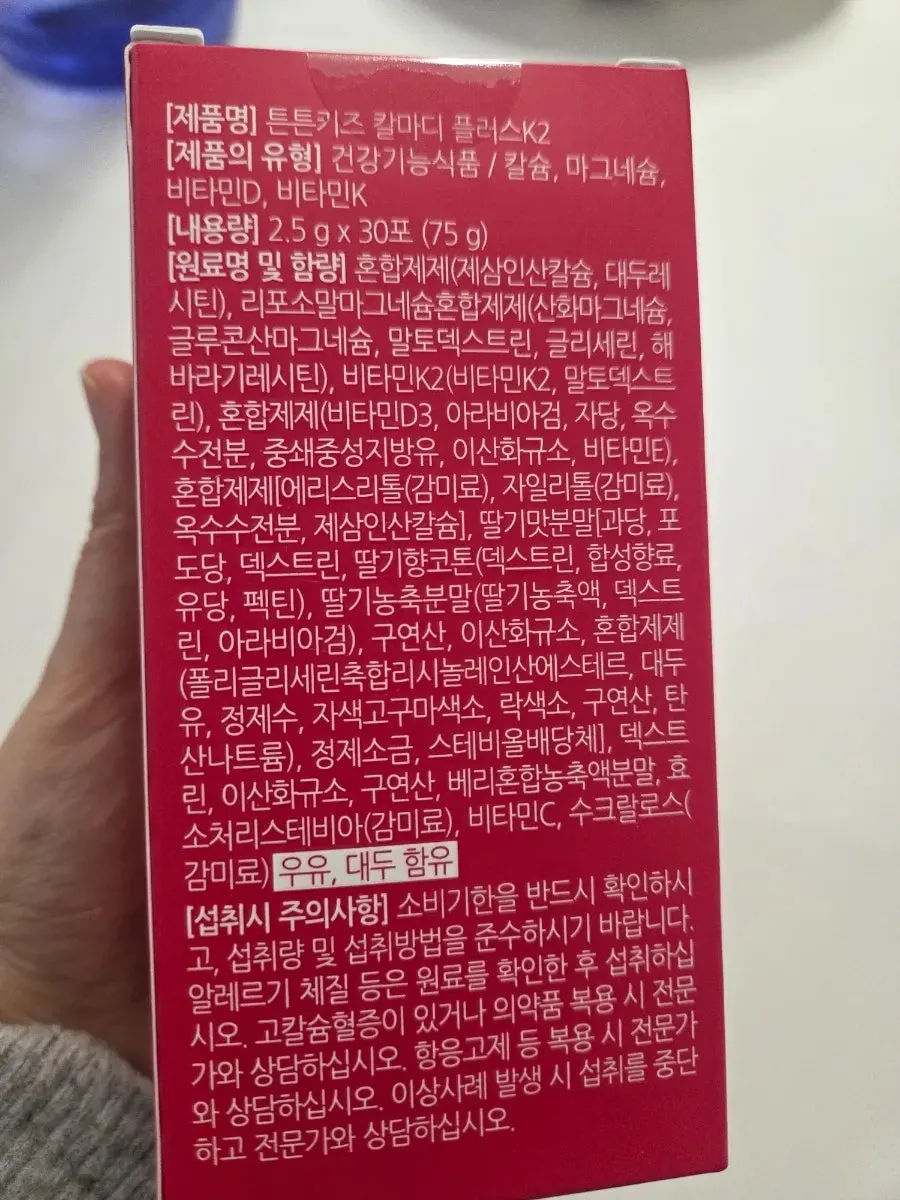 Strawberry-flavored Tunteun Kids Cal-Mag product given to a child