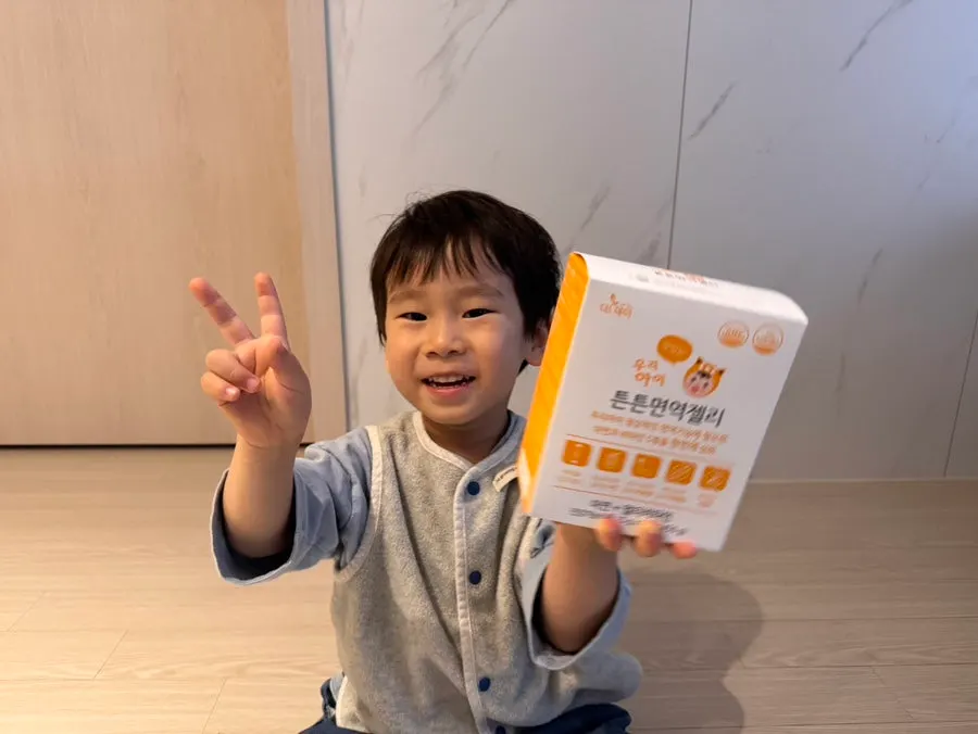 망고맛 비타민젤리를 들고 웃는 아이