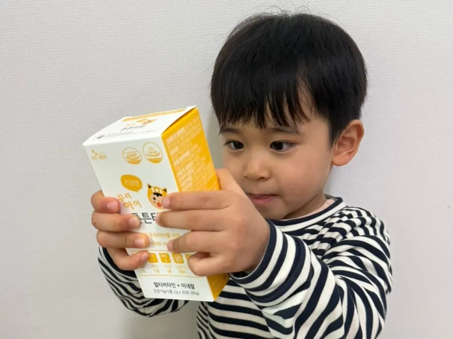 A child eating one sachet of mango-flavored multivitamin