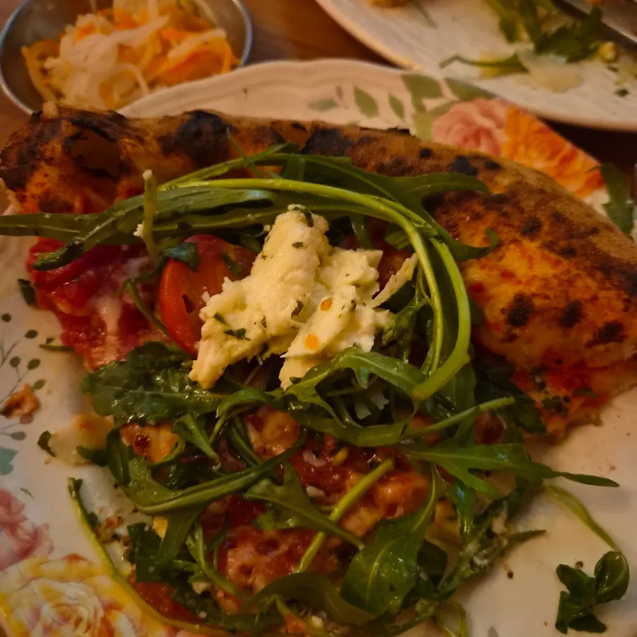 Charred marks on the crust edge of the wood-fired pizza