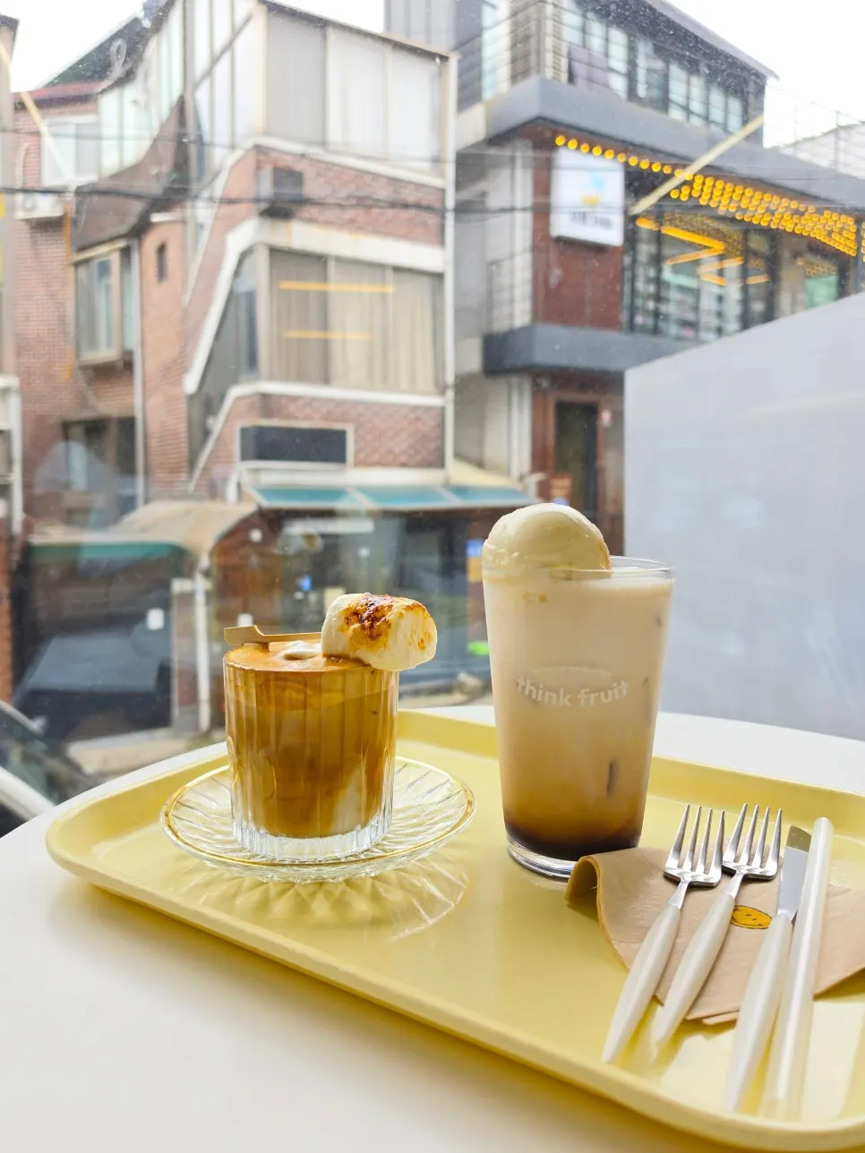 Dessert and drinks set on a window-side table at Think Fruit