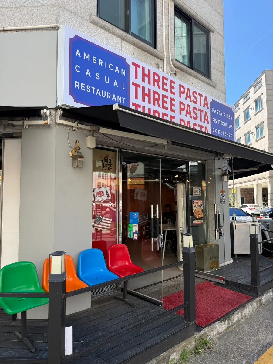 ป้าย THREE PASTA ริมถนนด้านหน้าร้าน