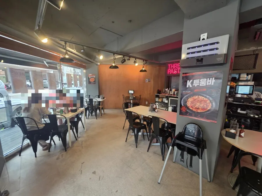 Seating area at Three Pasta lit with accent lighting