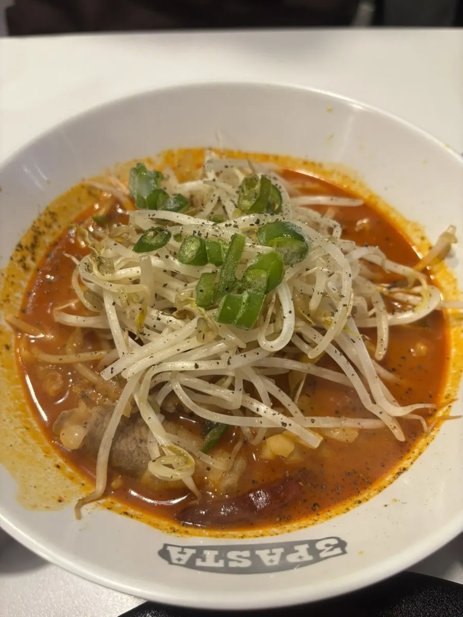 Woo-samgyeop jjamppong pasta topped with bean sprouts and beef belly