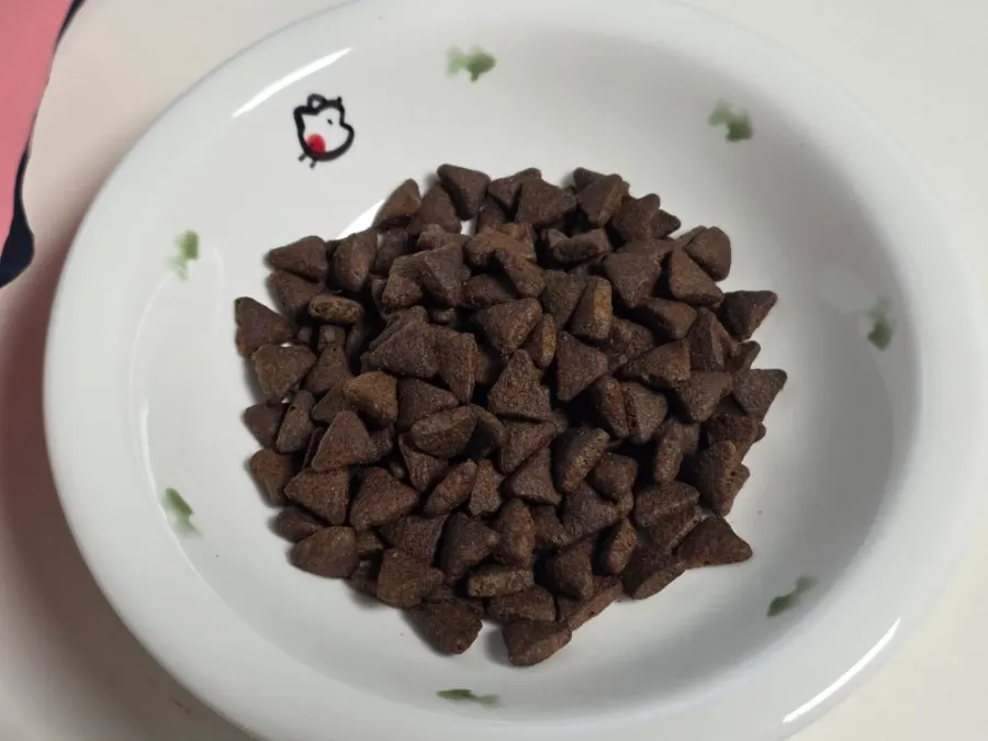Dark-brown triangular kibble from Thrive dry cat food