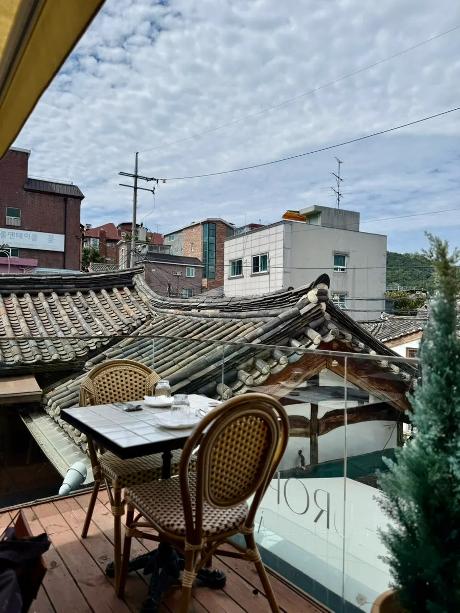 2nd floor terrace seats under a clear sky with clouds