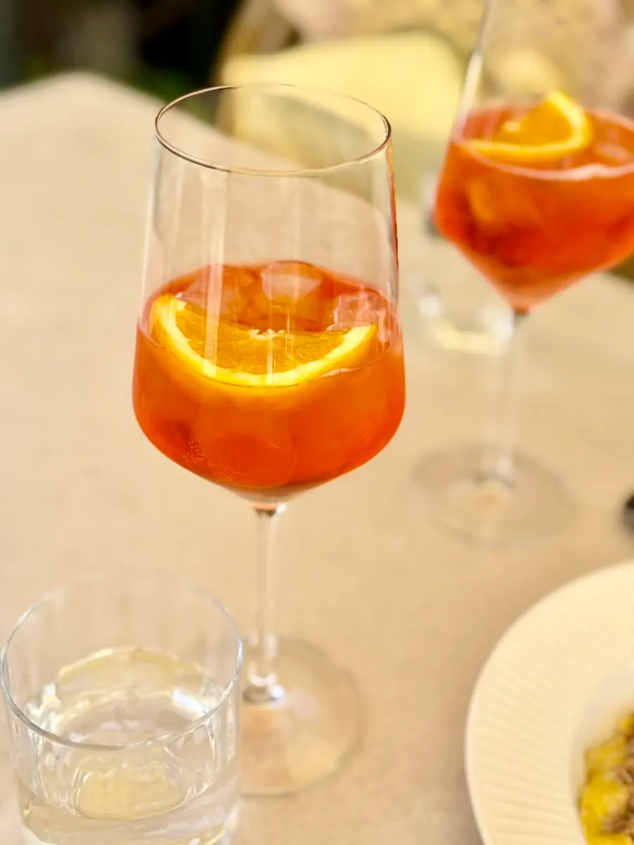 A glass of orange-hued Aperol Spritz