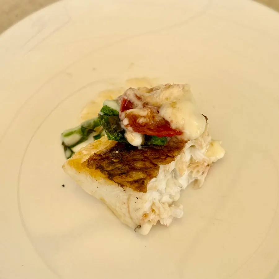 Grilled fish and pasta plated together on the table