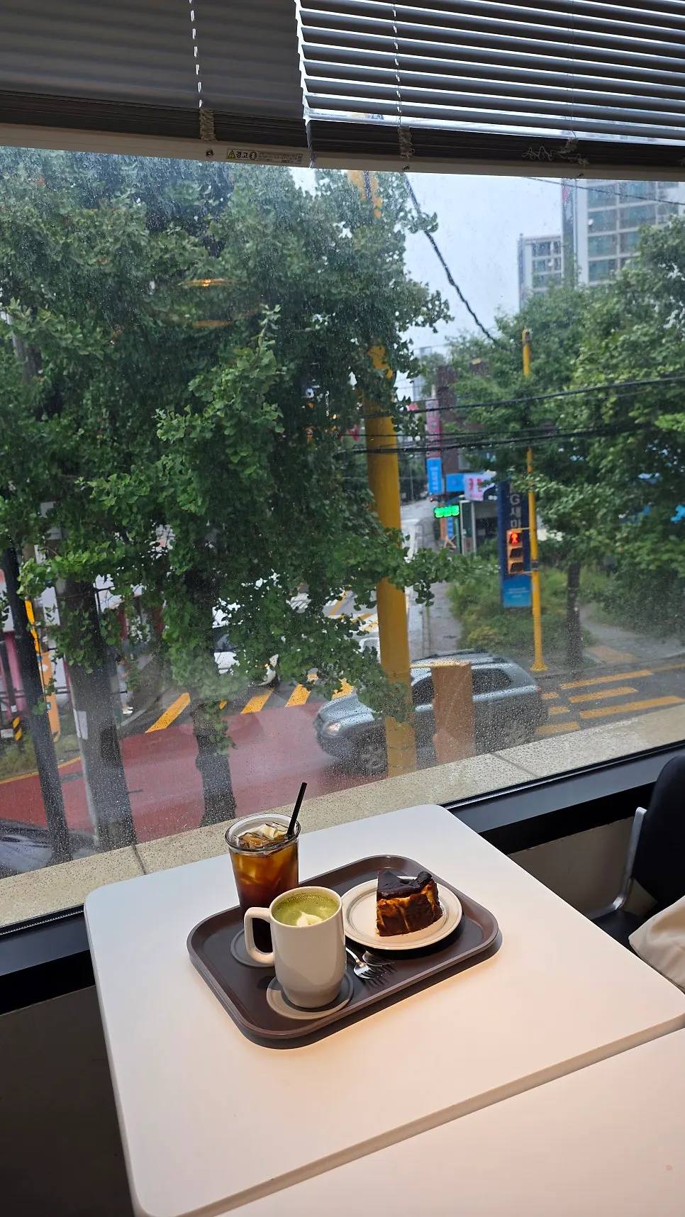 Stone-mill matcha latte, iced americano, and Basque cheesecake set on a table