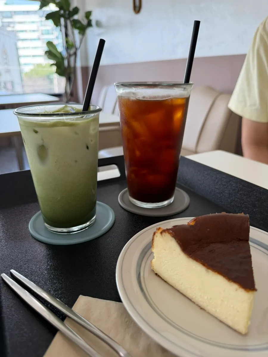 Matcha latte, americano, and Basque cheesecake spread on the table