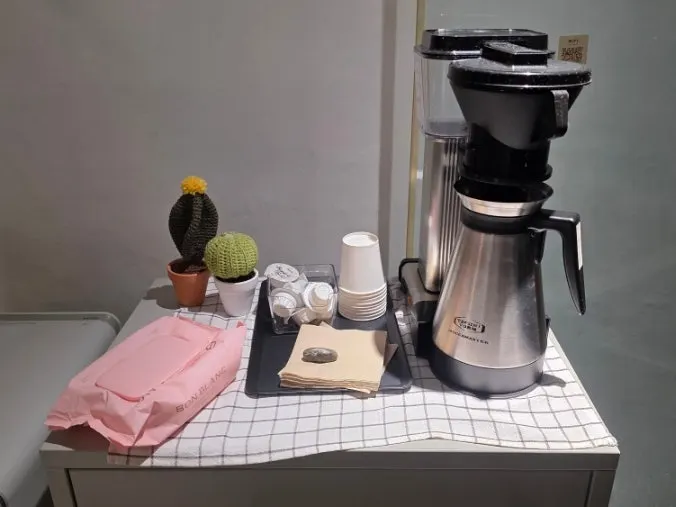 Amenity station at a floor entrance with syrup, tissues, wet wipes, and water