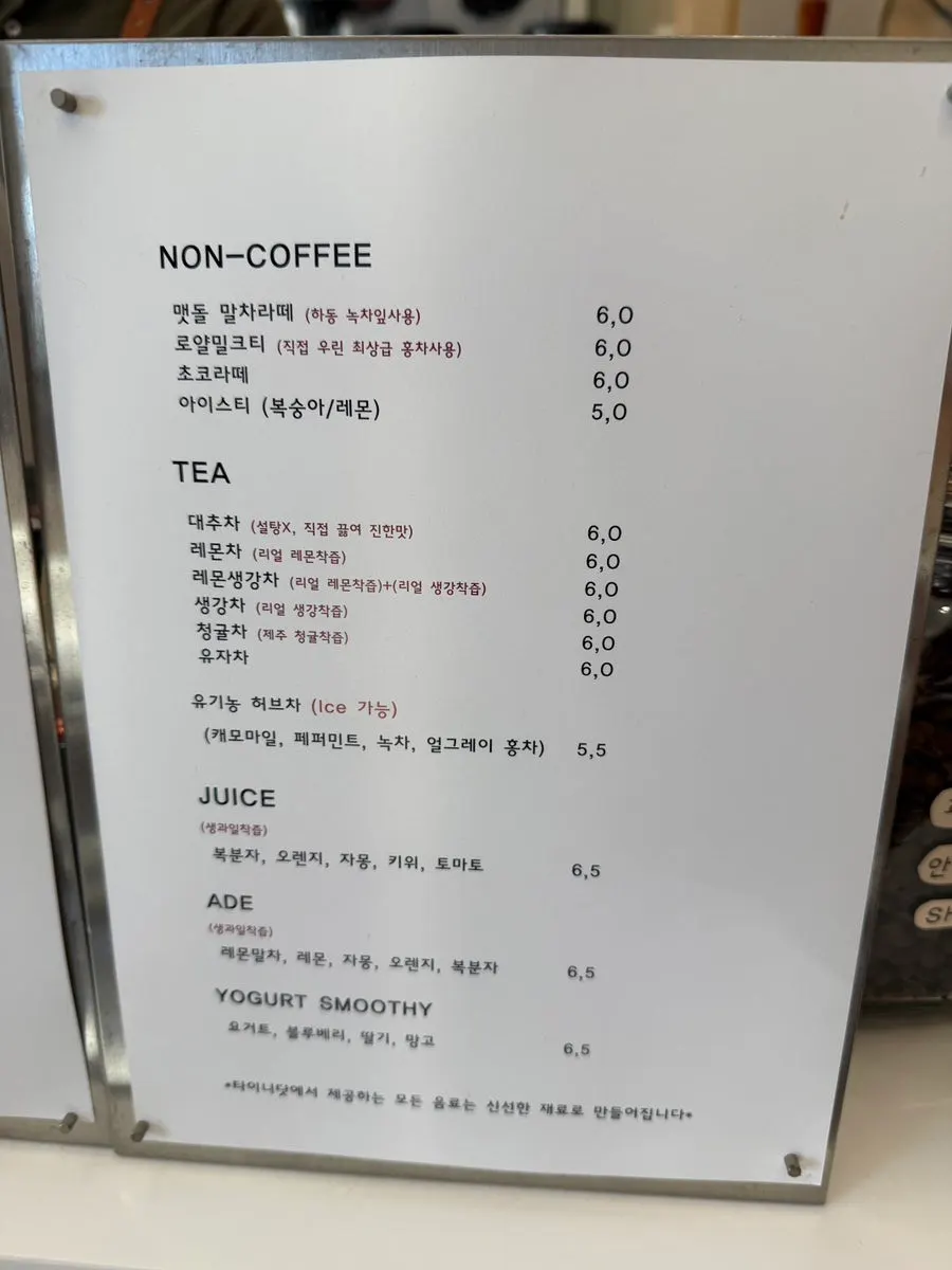 Menu board listing coffee, non-coffee drinks, and tea