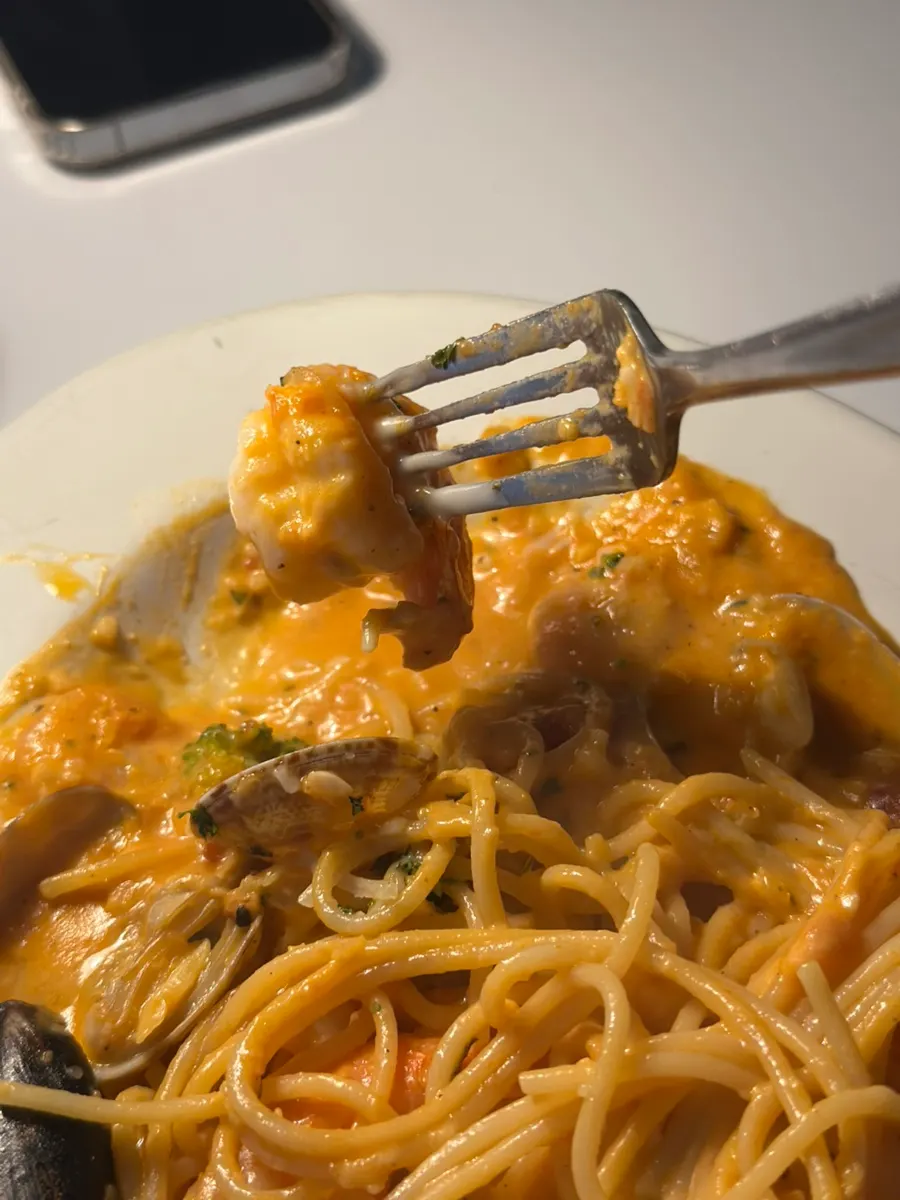Large prawns and clams on top of the rosé sauce