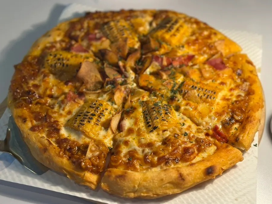 A whole freshly baked corn pizza