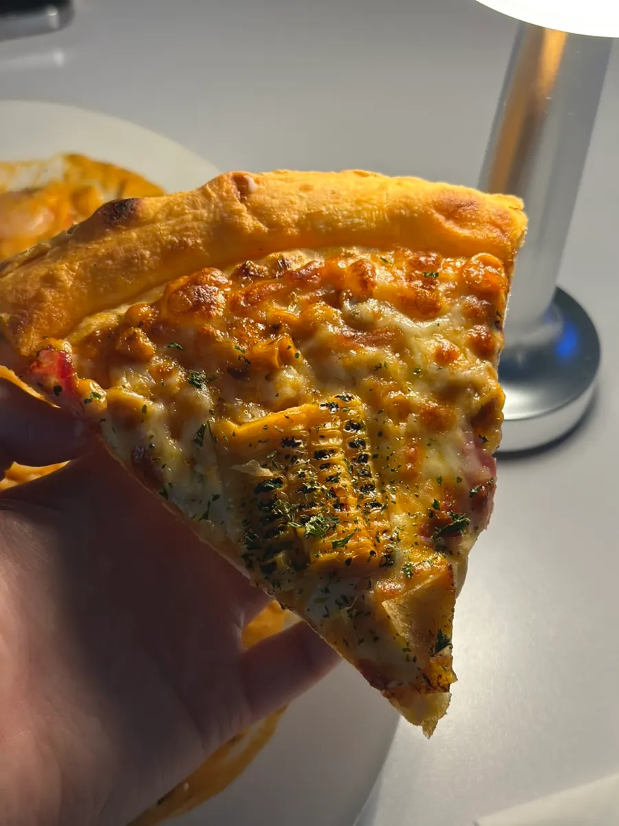 A slice of pizza topped with corn