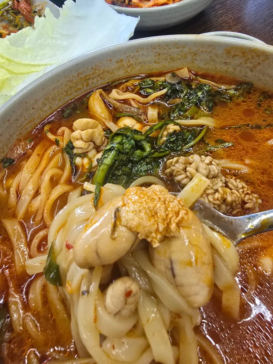 칼국수 그릇과 보쌈이 놓인 식탁