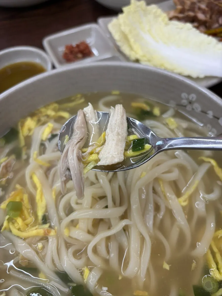 Noodles lifted from the chicken kalguksu broth