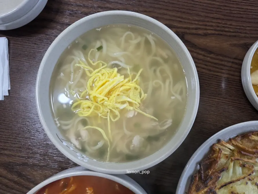 Bowl of Todamok's chicken kalguksu topped with egg strips