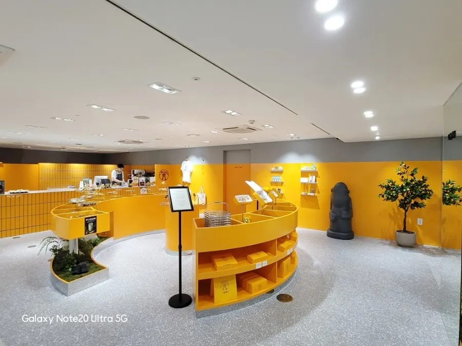 Wide view of Today Jeju's orange-toned display shelves