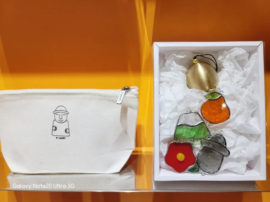 Display shelf with dol hareubang character pouches and Jeju souvenirs