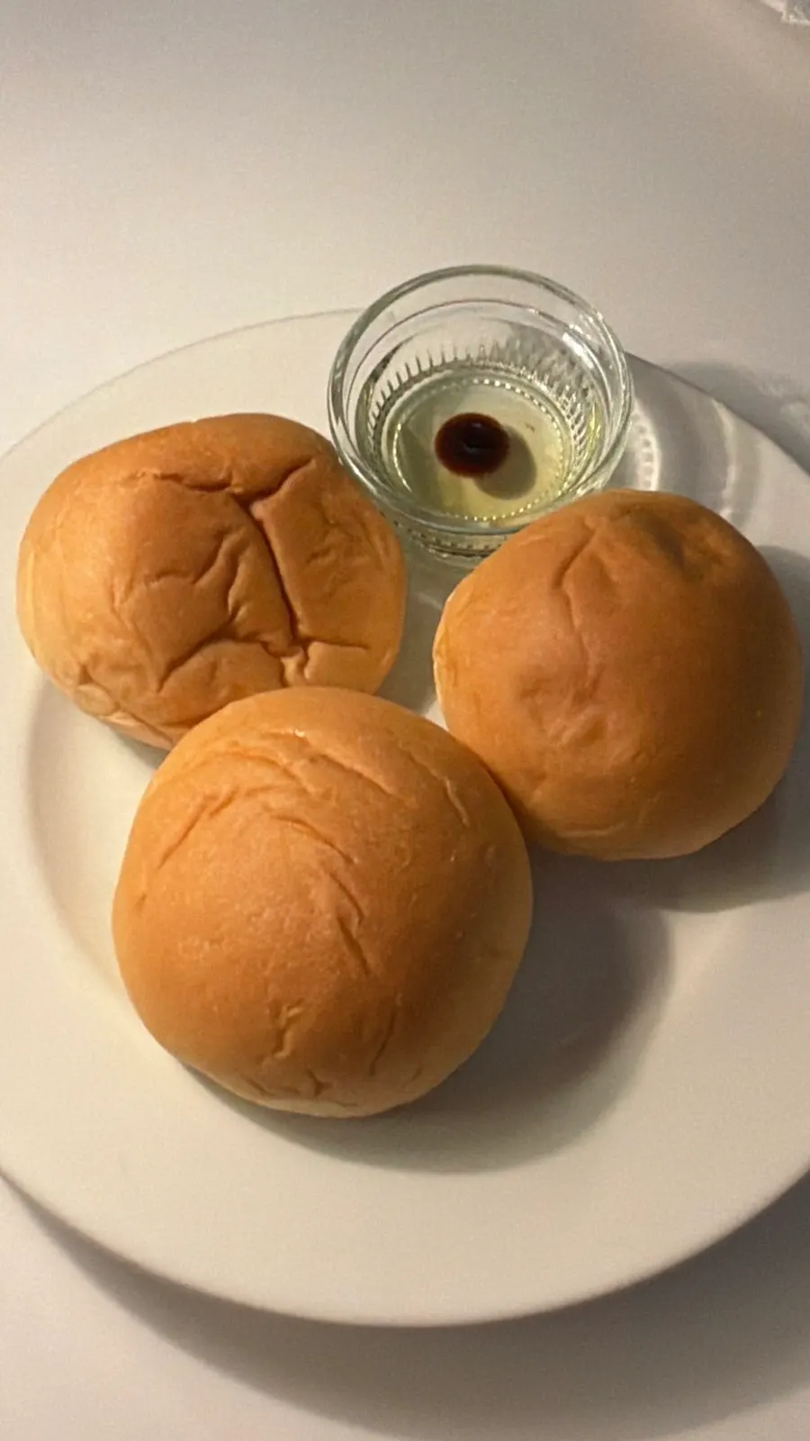 Warm pre-meal dinner rolls served with balsamic oil