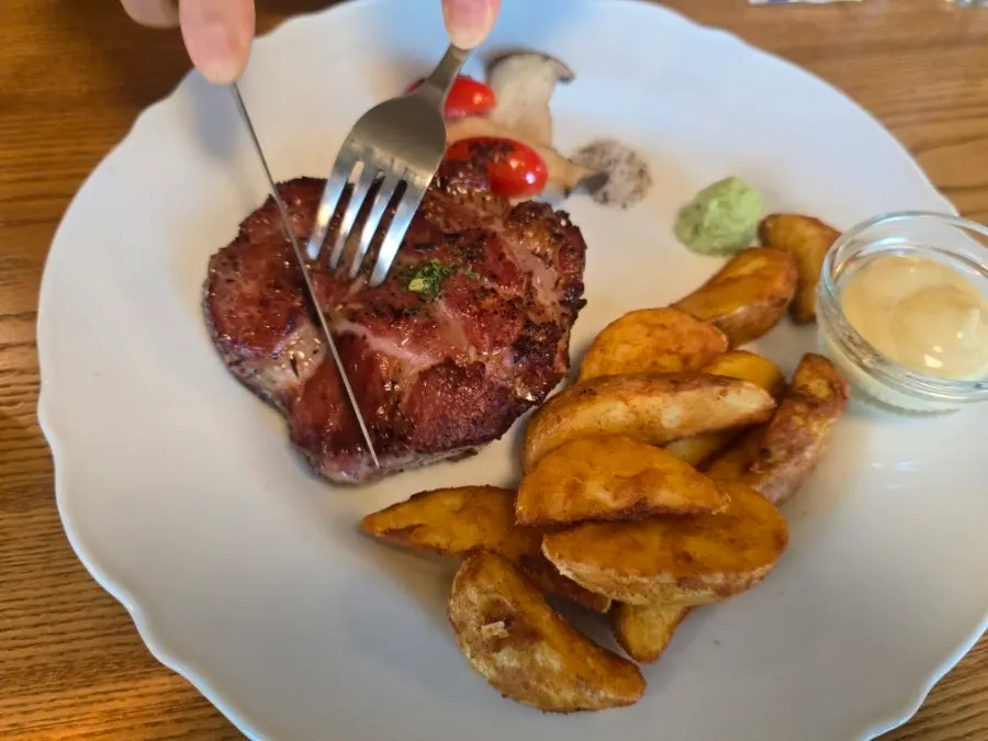 Sous vide pork collar steak served with grilled vegetables and fries