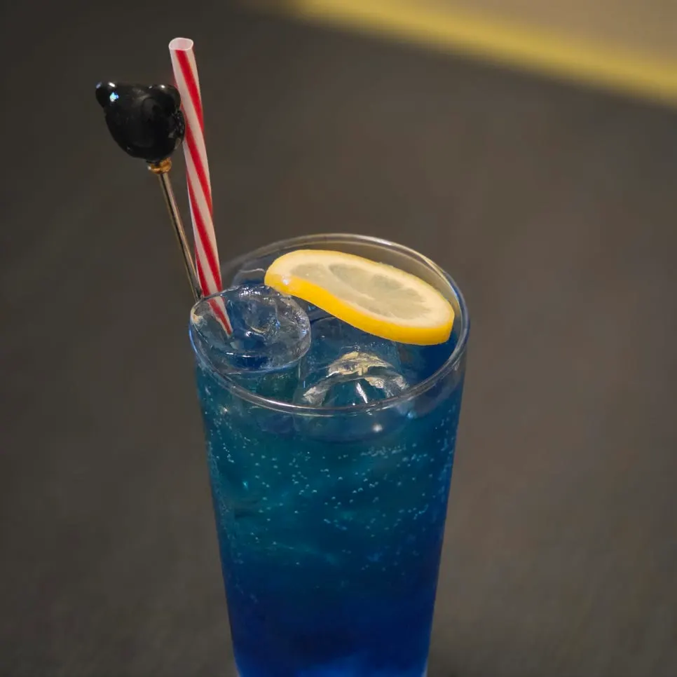 A glass of blue-tinted blue lemon highball
